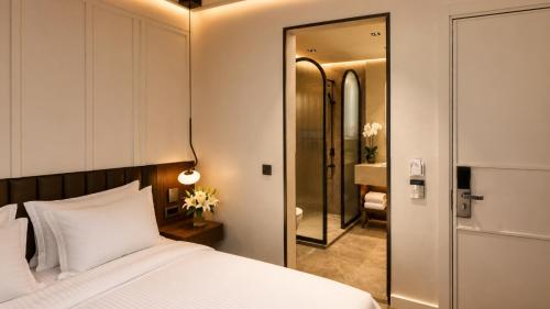 a bedroom with a white bed and a mirror at Alaturka Mansion in Istanbul