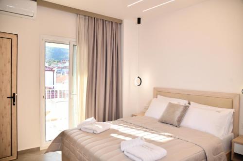 a bedroom with a bed with white sheets and a window at Villa Kostas Sarti in Sarti