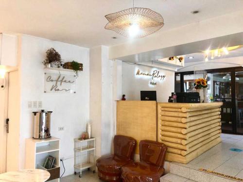 a restaurant with a waiting room with two brown chairs at Marian Palazz Hotel in Baguio