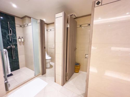 a bathroom with a shower and a toilet at Formosan Naruwan Hotel in Taitung City