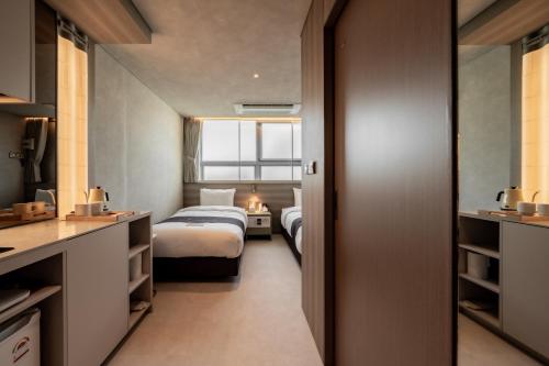 a hotel room with two beds and a window at My Me Hotel in Seoul