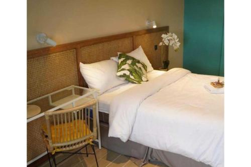 a bedroom with a white bed and a chair at Marian Palazz Hotel in Baguio