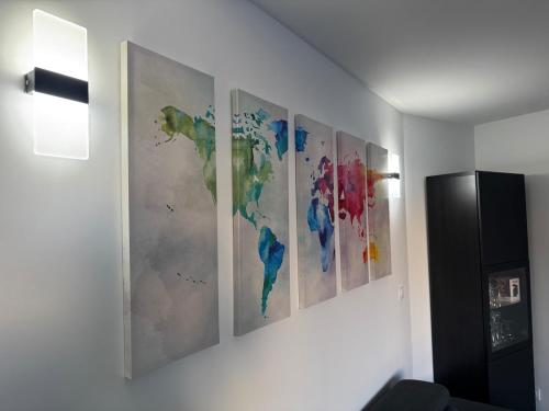 a group of four paintings on a wall at ღ L'Urban Gare - T3 Cosy Parking & Wifi in Douai