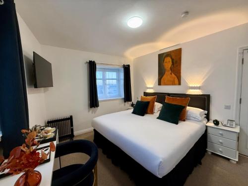 ein Hotelzimmer mit einem großen Bett und einem Schreibtisch in der Unterkunft Sarum Apart-Hotel in Saint Helier Jersey