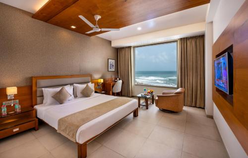a hotel room with a bed and a large window at Dwarkadhish Lords Eco Inn Dwarka - Pure Veg in Dwarka
