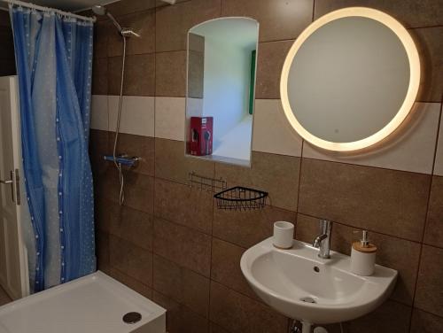 a bathroom with a sink and a mirror at Kaán Károly Kulcsosház in Kisapáti