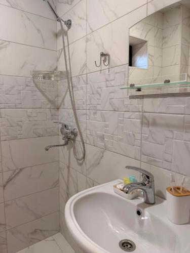 a white bathroom with a sink and a shower at Horizont Boutique Hotel in Telavi