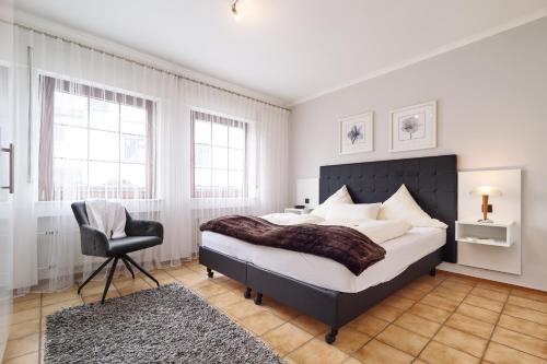 a bedroom with a large bed and a chair at Ferienweingut Port in Bernkastel-Kues
