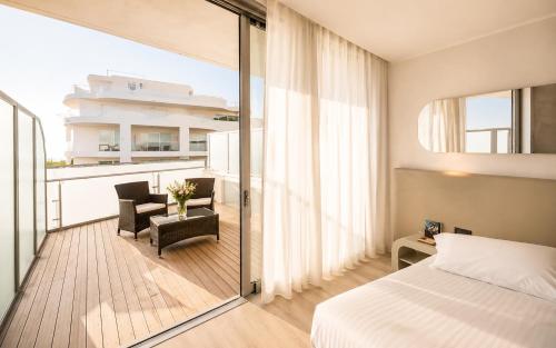 a bedroom with a bed and a desk and a chair at Hotel Le Palme - Premier Resort in Milano Marittima