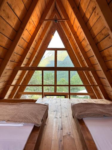 two beds in a room with a large window at Retreat Komovi in Andrijevica