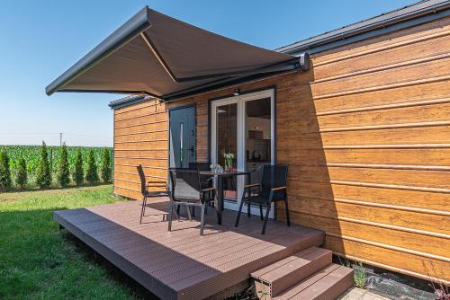 a wooden deck with a table and chairs on it at DOMKI#ENERGY Zator in Przeciszów
