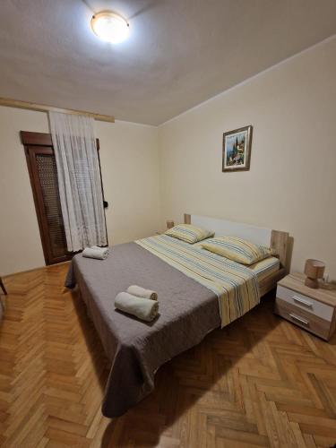 a bedroom with a bed with two towels on it at Apartman Dubravko Tribanj in Starigrad