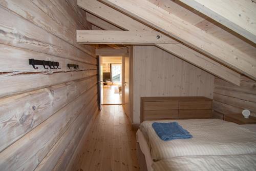 a bedroom with a bed and a wooden wall at Sommarbukt Nordlys - Private Arctic Retreat near Tromsø in Tromsø