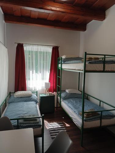 two bunk beds in a room with a window at Kaán Károly Kulcsosház in Kisapáti