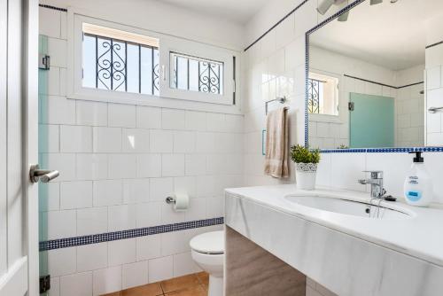 a white bathroom with a sink and a toilet at Villa Ribes by Escape Home in Binibeca