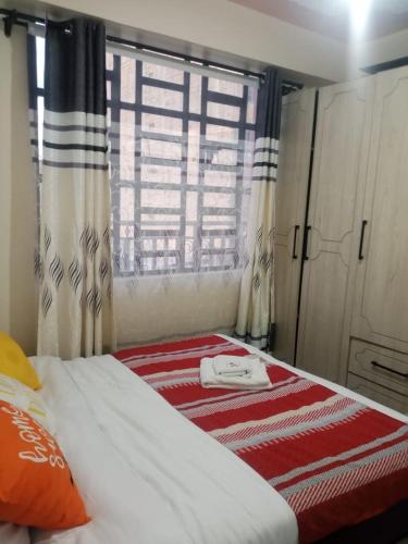 a bed in a room with a window and a bed sidx sidx sidx at Nanyuki Gratia Pad in Nanyuki