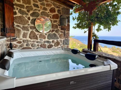 a hot tub in a stone building with a window at peaceful place in Anítsaion