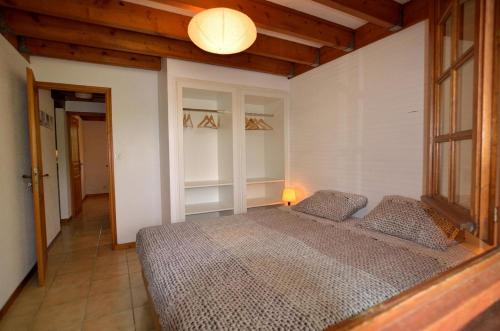 a bedroom with a bed in a room with a lamp at Les bouleaux in Cussac