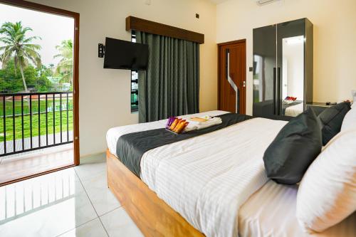 a bedroom with a large bed and a balcony at Uni Stay Inn in Cochin