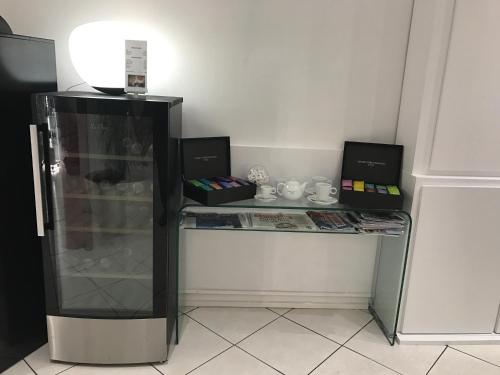 a desk with a glass refrigerator in a room at Hôtel Le Capitole in Toulouse