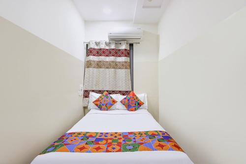 a small room with a bed and a curtain at FabHotel Anu Grand - Vijayawada in Vijayawāda