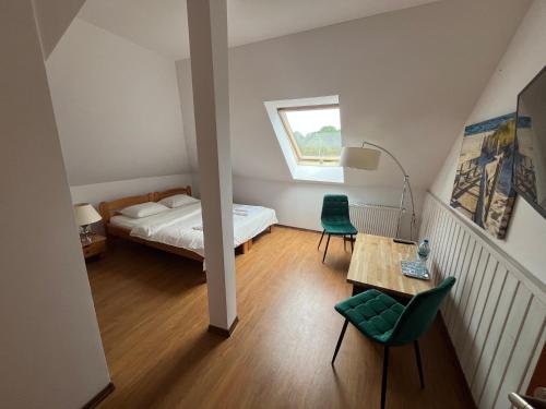a bedroom with a bed and a table and chairs at Dworek na Polance in Wrzosowo