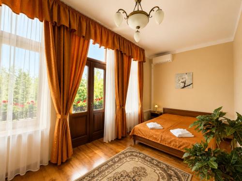 a bedroom with a bed and a large window at Olymp penzion in Komárno