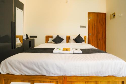 a bedroom with a large bed with two towels on it at Uni Stay Inn in Cochin