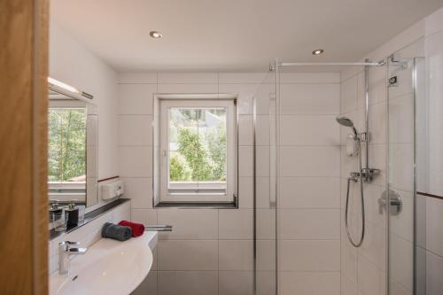 a white bathroom with a sink and a shower at Appartement Désirée inkl der SUPER SOMMER CARD im SOMMER 2026 in Serfaus