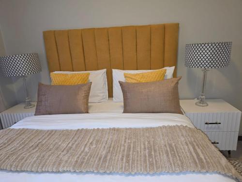 a bedroom with a large bed with two lamps at Classy and Cosy 5 in Fourways