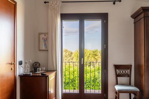 a room with a door with a view of a balcony at Hotel Resort La Rosa Dei Venti in Portopalo