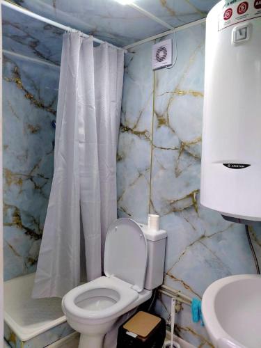 a bathroom with a white toilet and a sink at Eagle's Nest in Karakol
