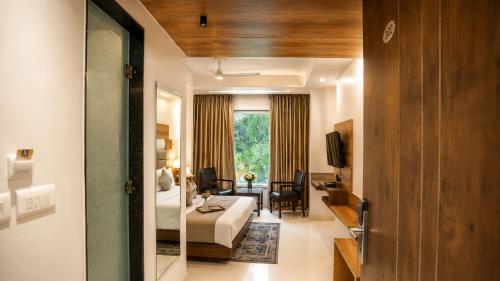 a hotel room with a bed and a living room at Hotel Sopan Heights in New Delhi