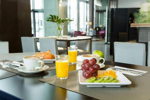 a table with a tray of fruit and orange juice at Sercotel Boulevard Vitoria-Gasteiz in Vitoria-Gasteiz