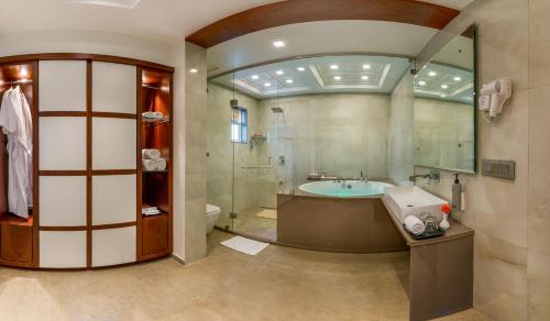 a large bathroom with a tub and a sink at Dwarkadhish Lords Eco Inn Dwarka - Pure Veg in Dwarka