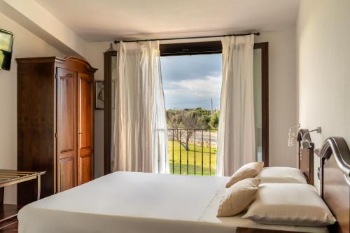 a bedroom with a bed and a large window at Hotel Resort La Rosa Dei Venti in Portopalo