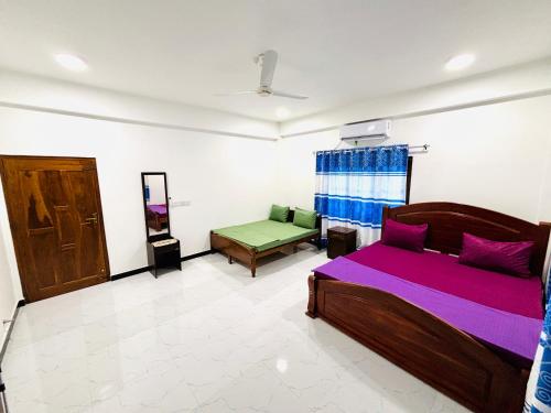 a bedroom with a bed and a couch in it at Viyona Guest House in Trincomalee