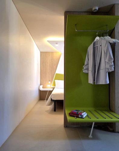 a room with a green wall and a bedroom at Cristal Hotel Palermo in Palermo