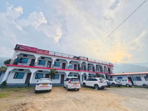 a building with cars parked in front of it at R K Hotel & HELY ROOMS in Phata