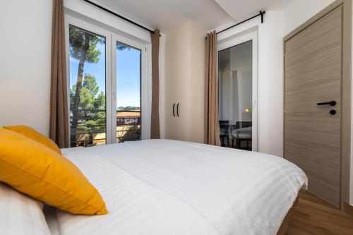 a bedroom with a white bed and a large window at Sanpier Apartments in Veli Lošinj