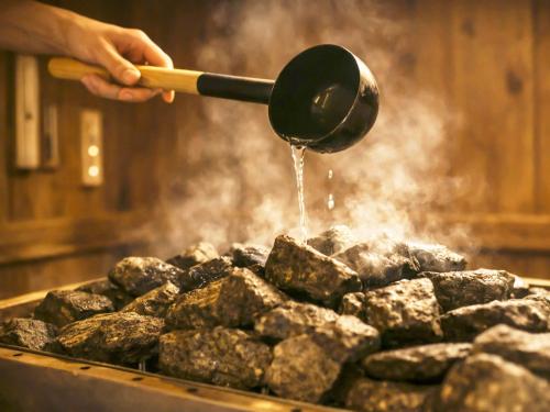 a person cooking food on a grill with a spatula at Hotel Rose (Adult Only) in Gifu