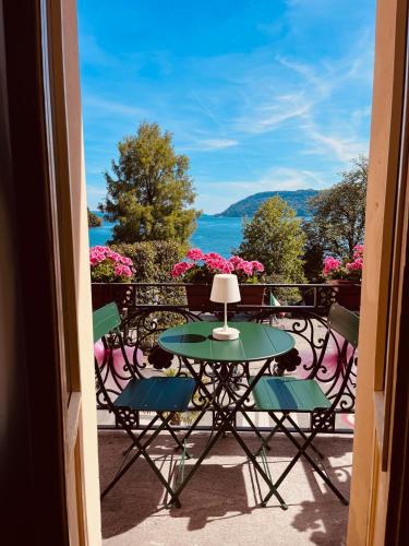 a patio with a table and chairs on a balcony at Casa Gambusso historical house magnificent Lake View in Verbania