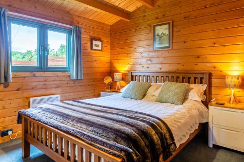 a bedroom with a bed in a log cabin at Oakbank Farm in Lamlash