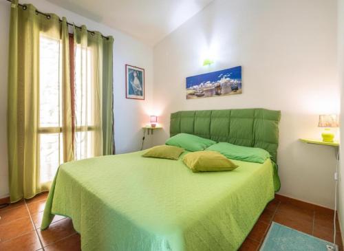 a bedroom with a green bed with two pillows on it at Villa Fior di mare in Monte Nai