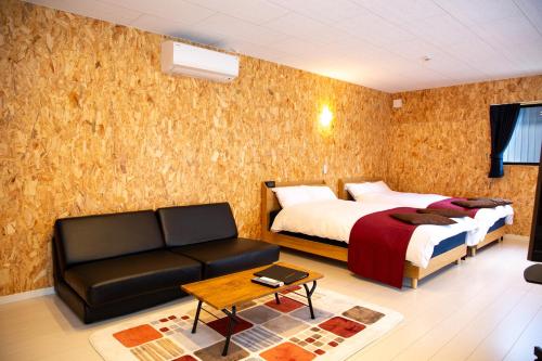 a hotel room with a bed and a couch at Win Village in Sasebo