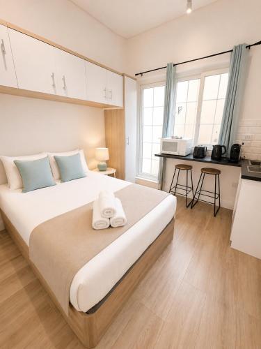 a bedroom with a large bed and a kitchen at Grand Central House - Classic Studio - GibraltarStay Apartments in Gibraltar