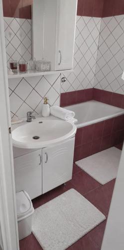 a bathroom with a sink and a tub and a toilet at Jucus Apartman in Makó