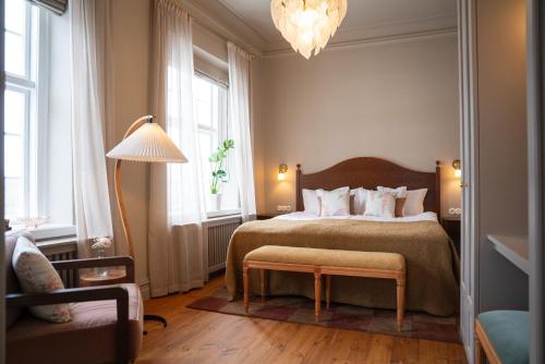 a bedroom with a bed and a lamp and windows at Krusenberg Herrgård in Krusenberg