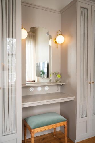 a bathroom with a mirror and a green stool at Krusenberg Herrgård in Krusenberg
