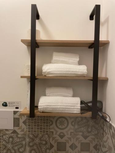 a shelf with white towels on it in a room at B&B La Via di Casa in San Leone